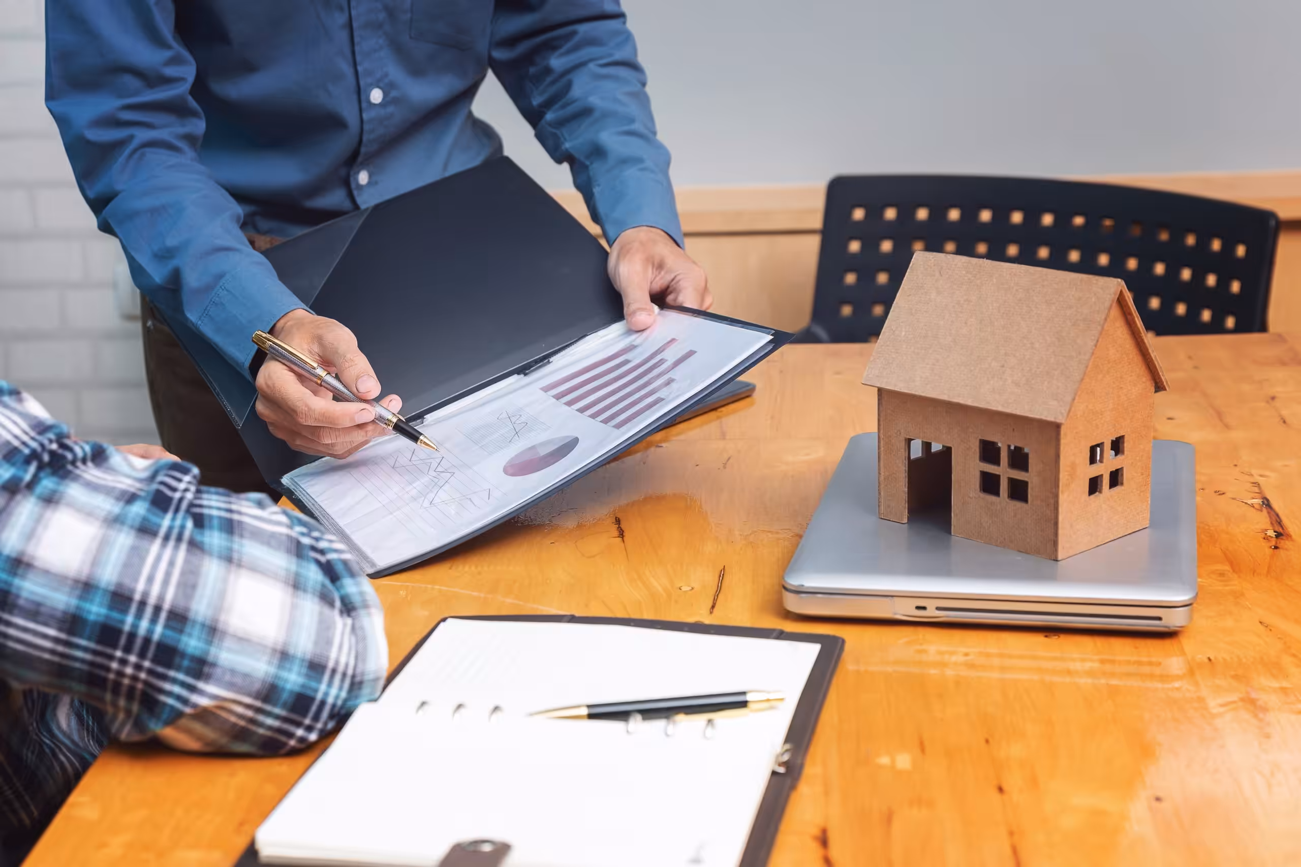 Real estate agent showing his client about property detail.